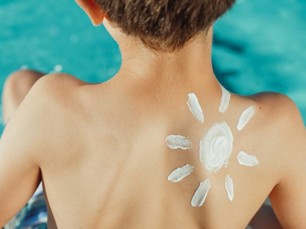 Sunscreen for UV index shown being applied on a person’s upper back to protect skin from strong ultraviolet exposure.